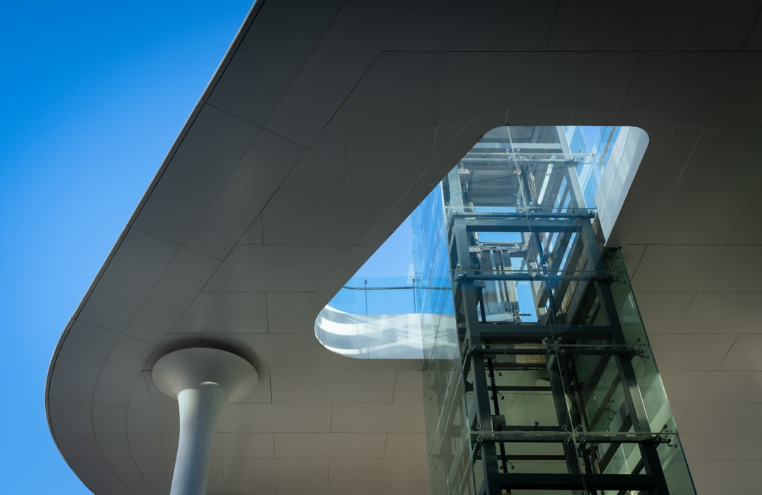 modern-building-with-glass-elevator-and-blue-sky-mfgzv2-fzfs